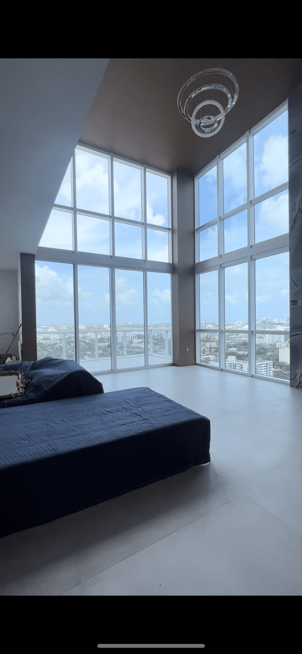 Modern penthouse with floor-to-ceiling tinted windows overlooking the city